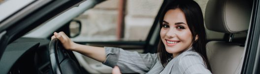 Woman sitting in the car and showing thumbs up